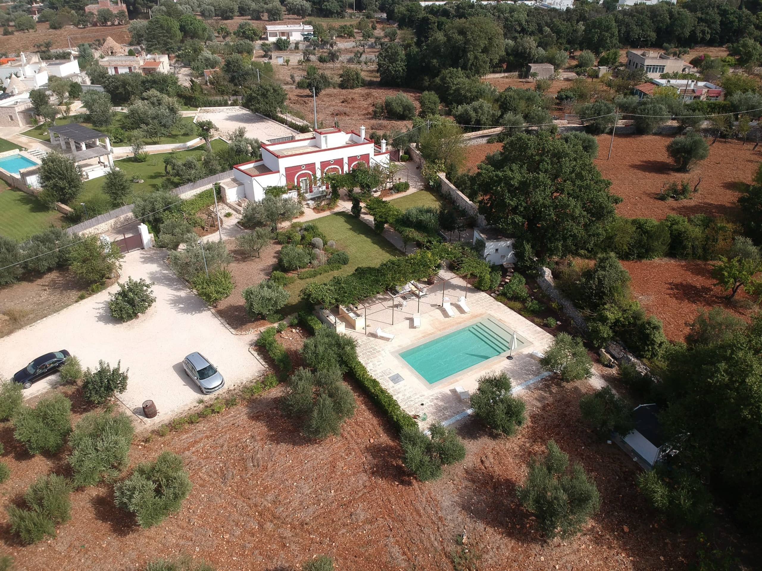 La masseria et sa piscine vues du ciel, au milieu des oliveraies de la campagne de Polignano