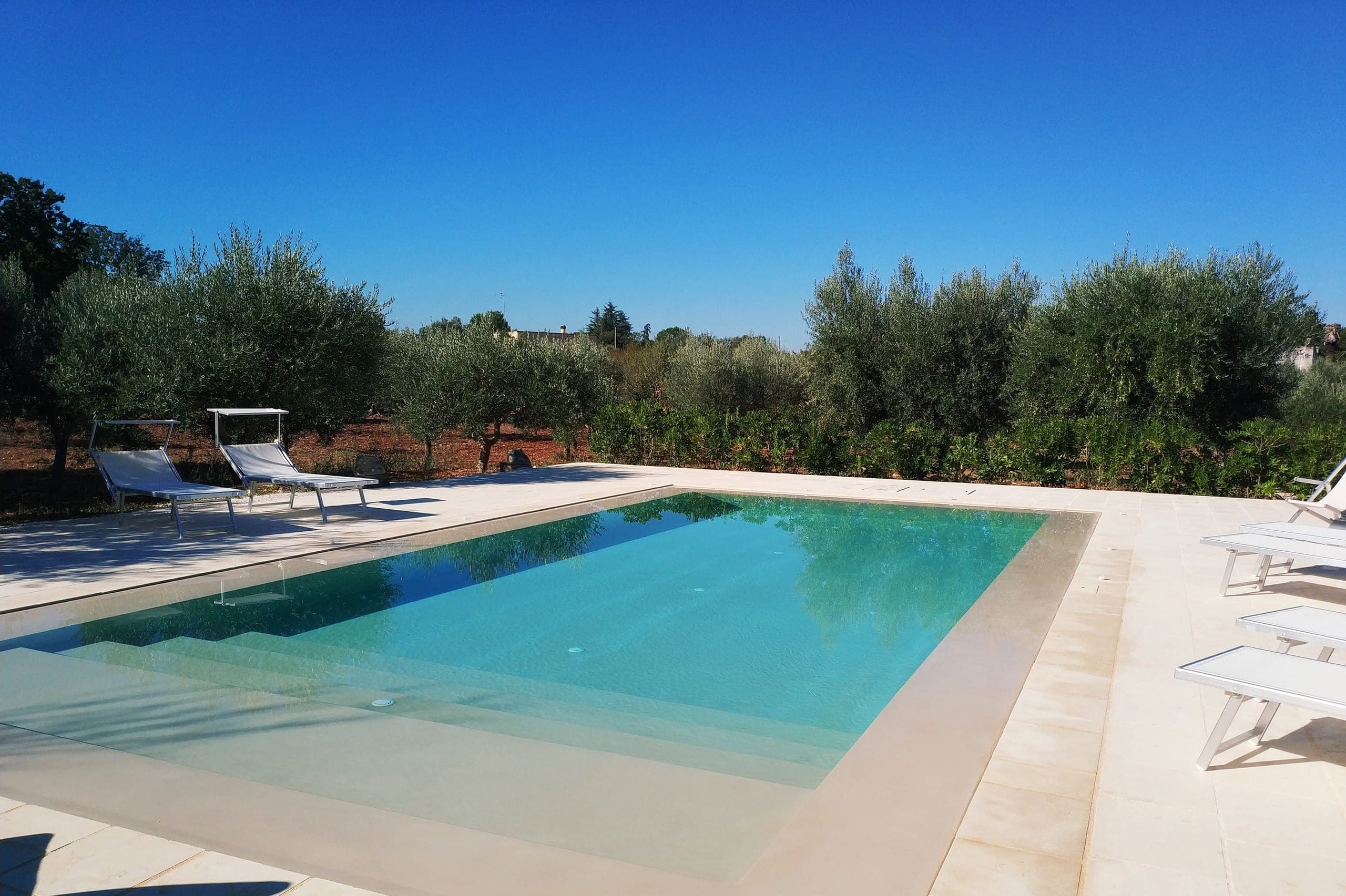 La piscine à débordement d'eau salée, au ras de l'eau sous les oliviers