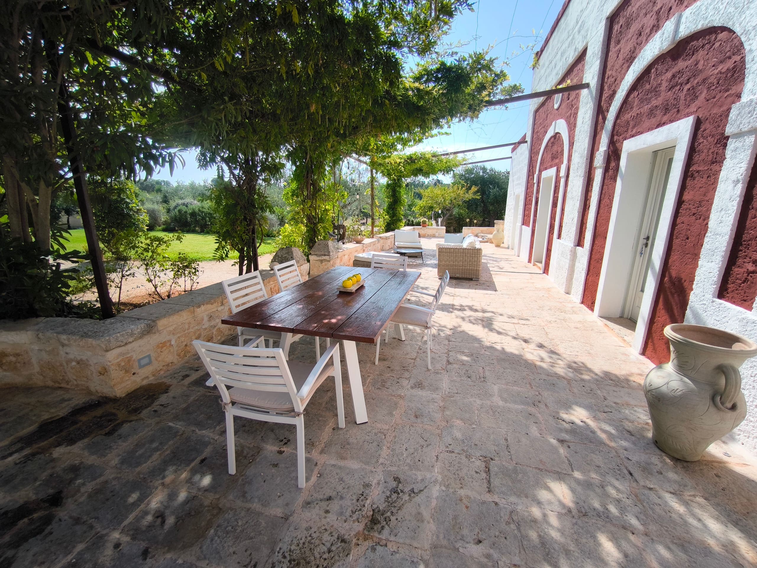 Table dressée sur la grande terrasse en pierre apulienne, au soleil