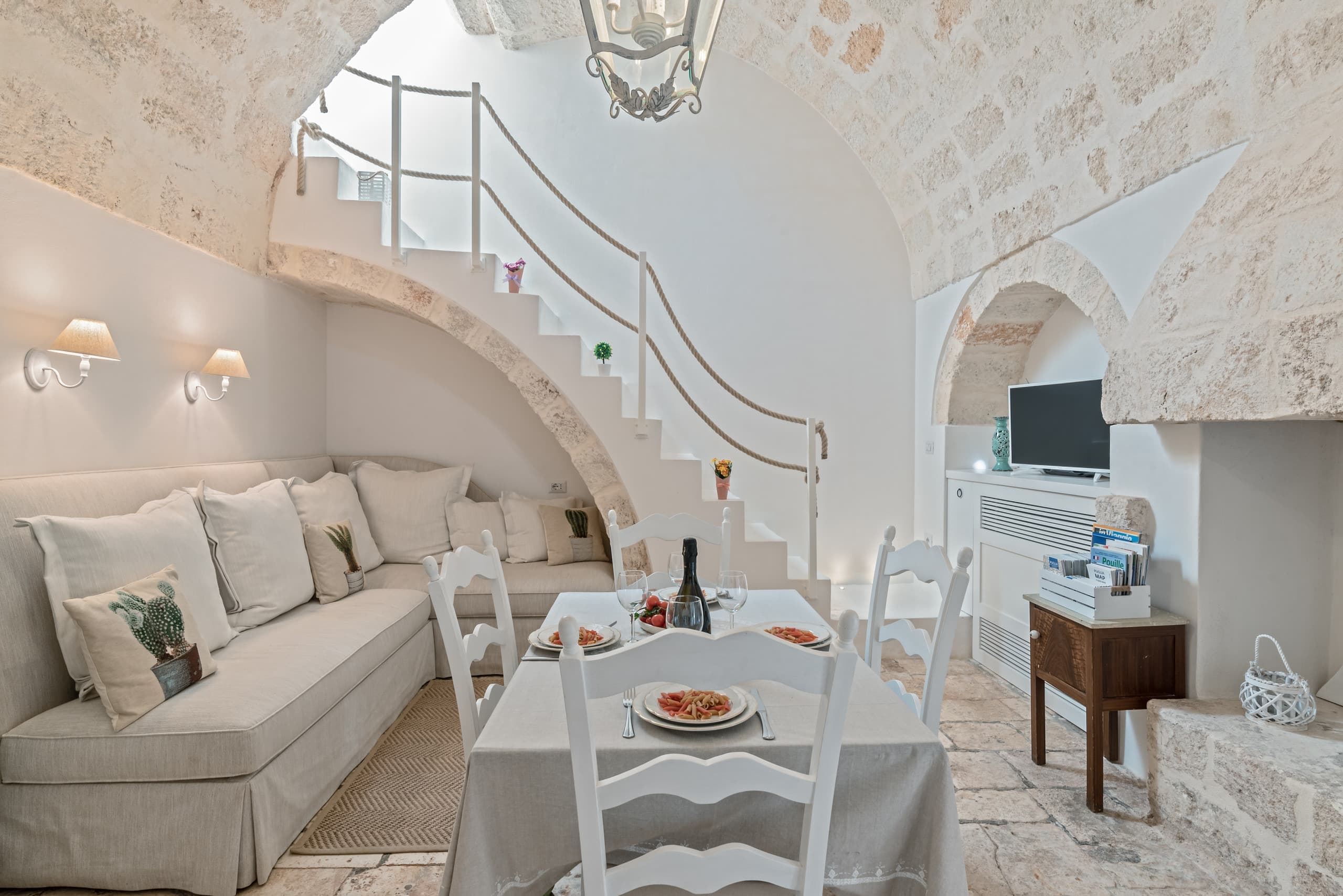 The apartment's vaulted living room and its stone staircase to the terrace
