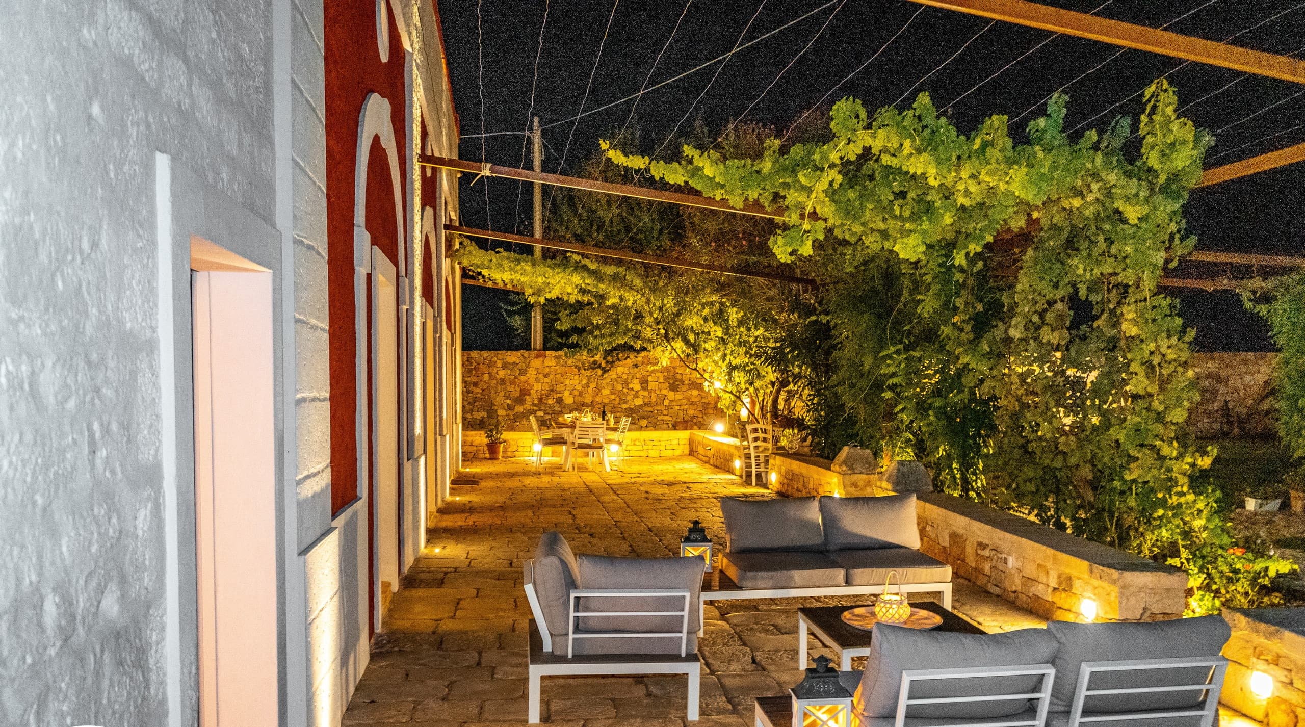 Le salon de la terrasse au crépuscule, lanternes allumées face à la campagne